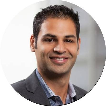 Professional headshot of a smiling man in a suit.